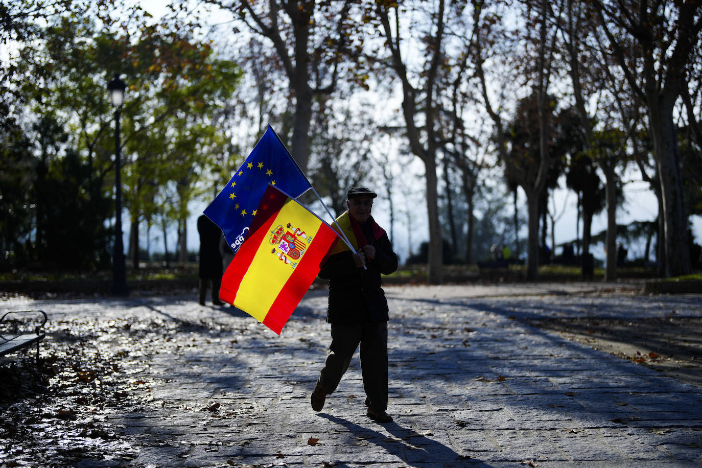 Un hombre se dirige hacia el Templo de Debod para participar en la manifestación contra la amnistía con banderas de España y Europa