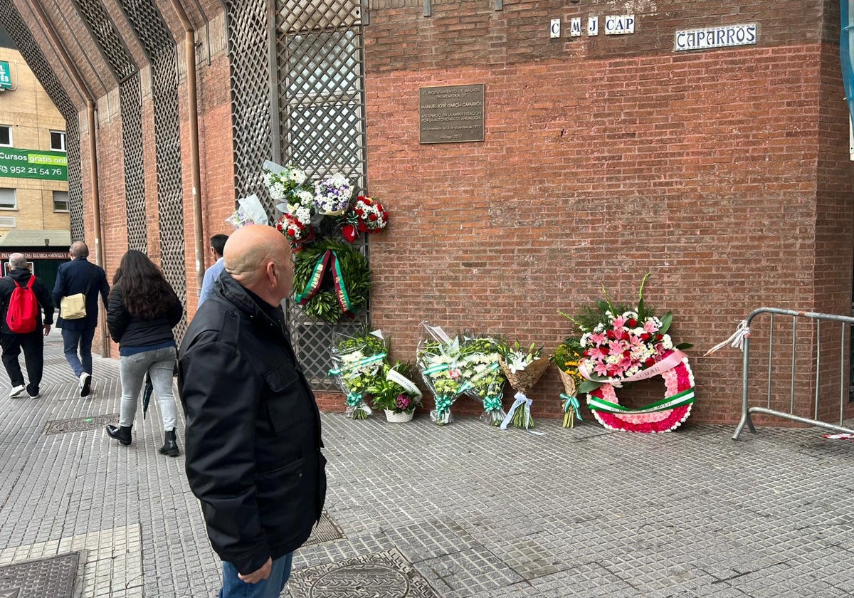 Un ciudadano se para ante las ofrendas florares por la muerte de García Caparrós en Málaga en el lugar de su muerte