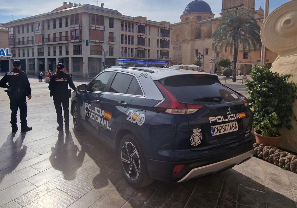 Dos agentes de la Policía Nacional junto a un coche patrulla, en imagen de archivo.