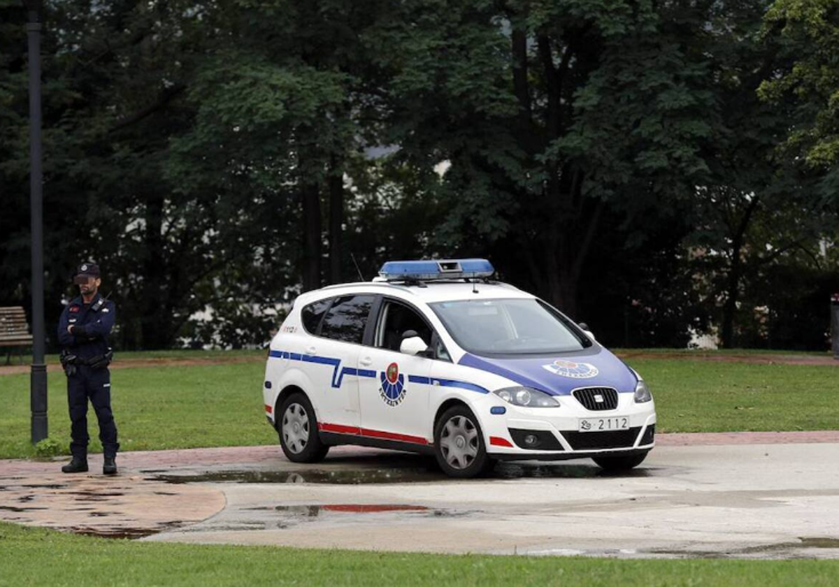 Un ertzaina vigila junto a un coche patrulla en una imagen de archivo