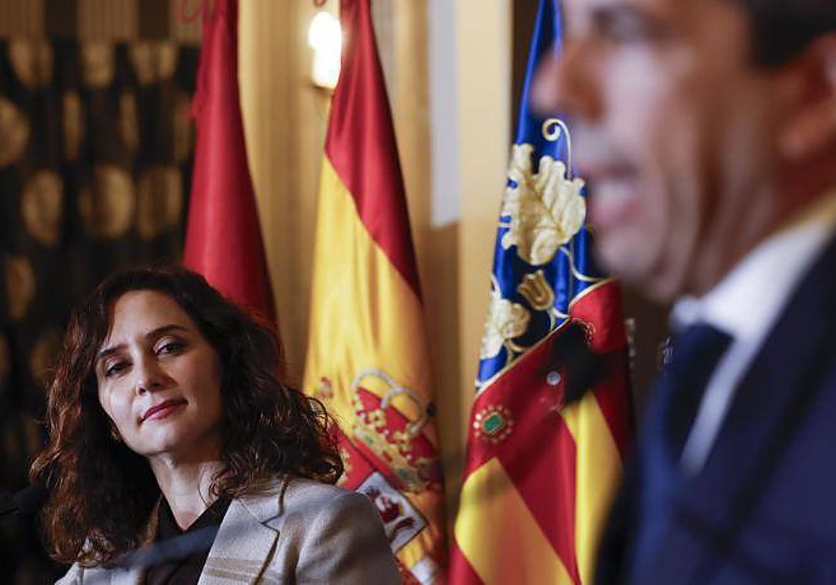 La presidenta de la Comunidad de Madrid, Isabel Díaz Ayuso, escucha a Carlos Mazón