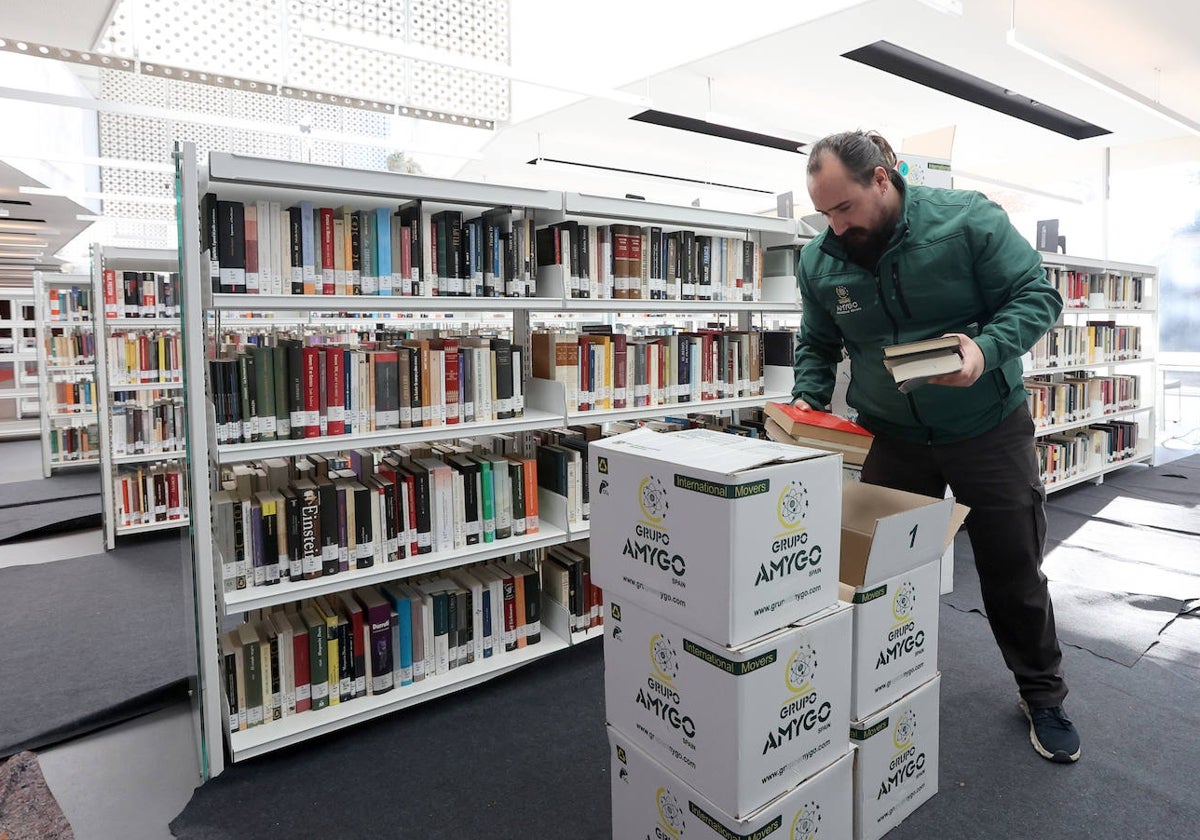 Un trabajador de la empresa de mudanzas saca los libros para disponerlos en su nueva ubicación en la Biblioteca Grupo Cántico