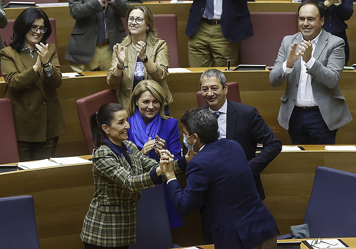 Imagen del presidente de la Generalitat, Carlos Mazón, felicitando a la consellera de Hacienda, Ruth Merino, este miércoles en las Cortes Valencianas
