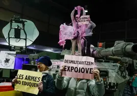 Un grupo de vándalos vestidos de payaso rocía con pintura rosa un tanque del Ejército en la feria Expojove de Valencia