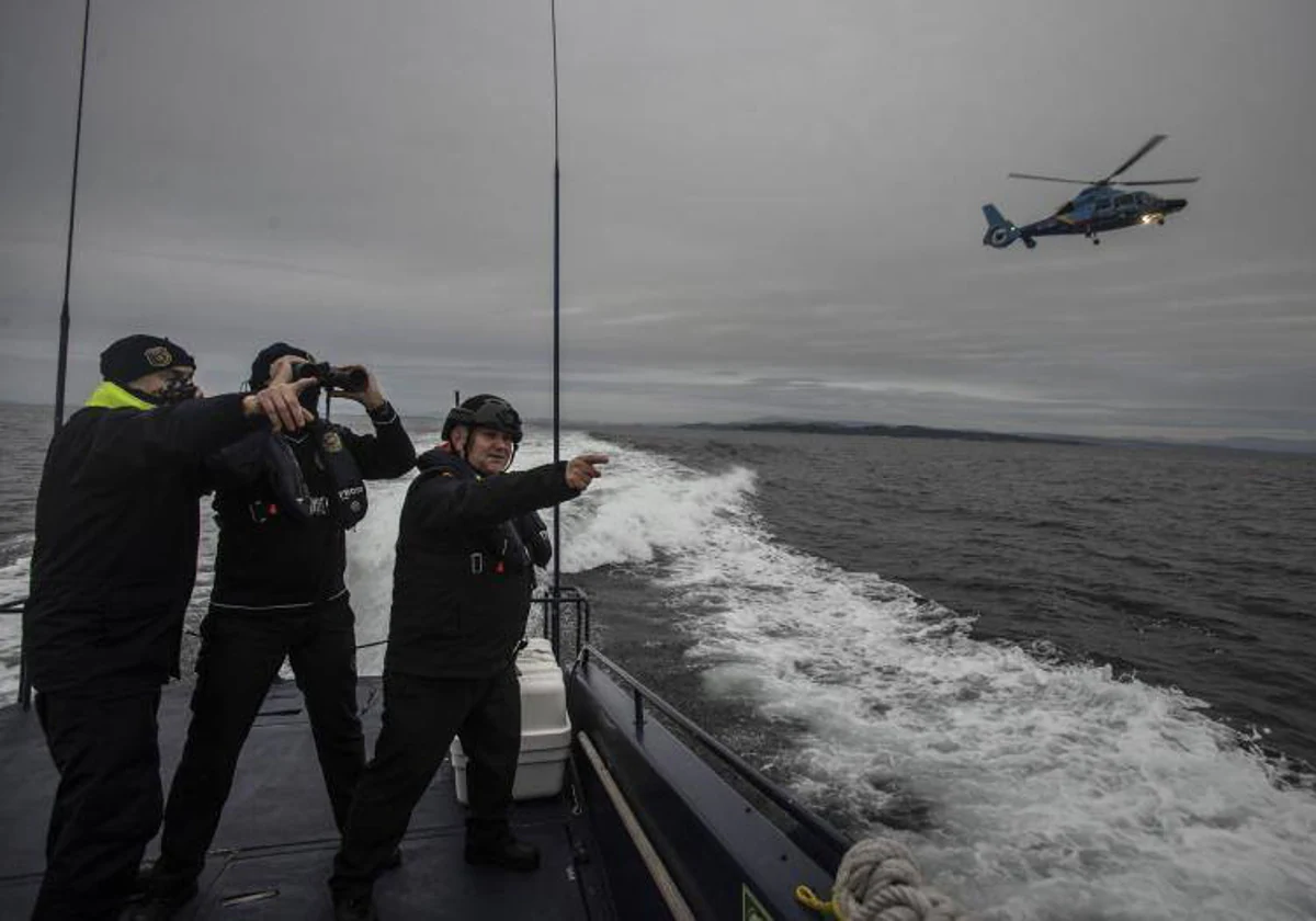 Patrullaje del Águila V por la ría de Arousa (Pontevedra), en el helicóptero al fondo