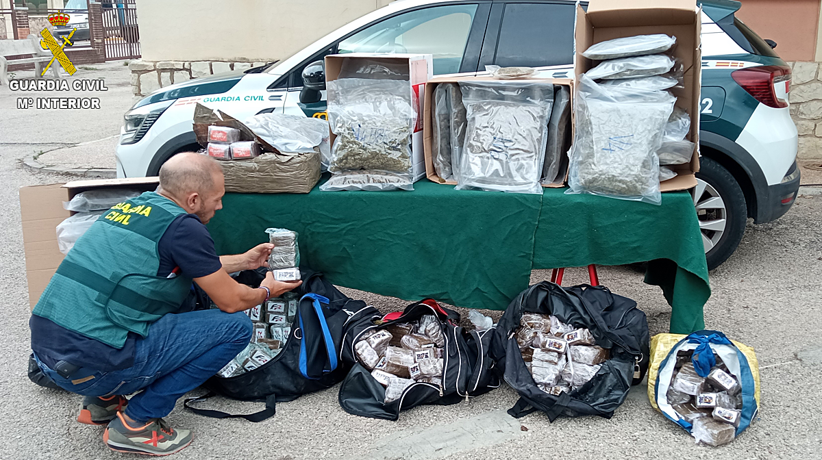 Un agente de la Guardia Civil revisa las latas de conserva intervenidas con drogas en la opeeración 'Humanfont'.