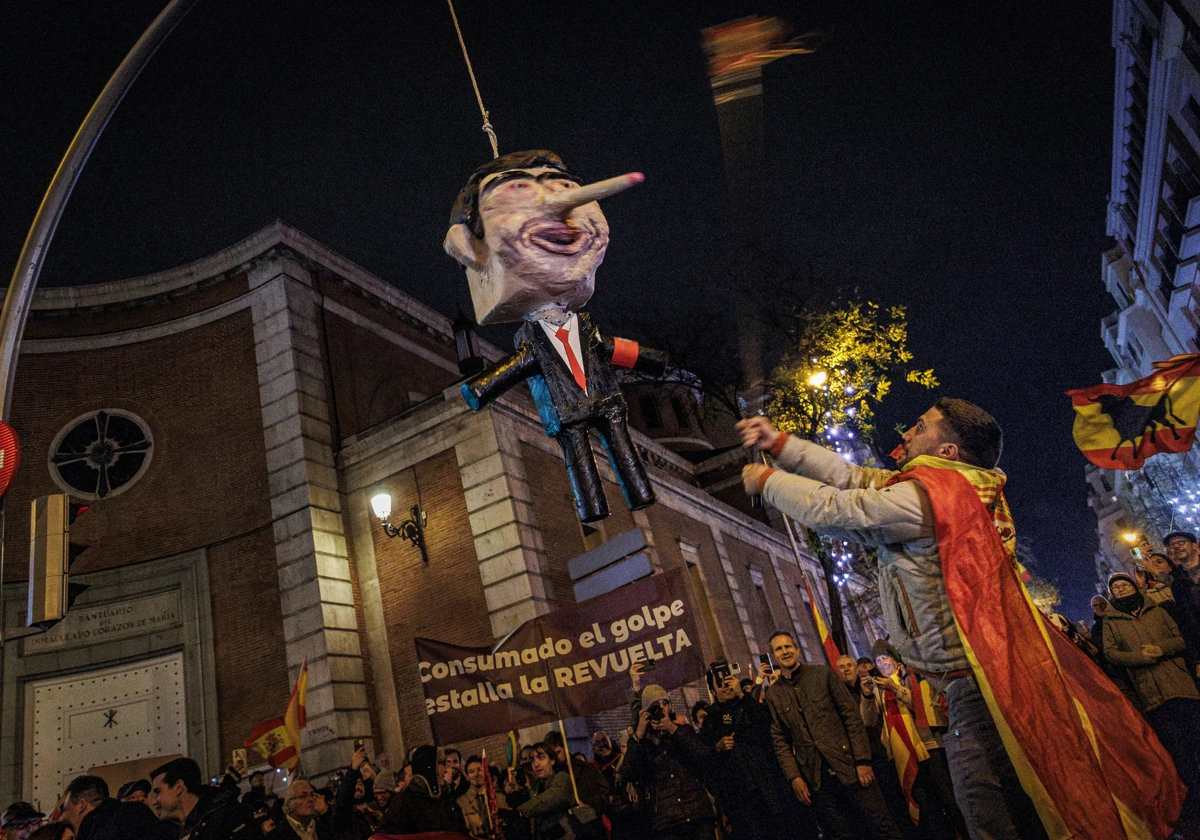 Un instante de la protesta de Ferraz en Nochevieja con el muñeco de Sánchez zarandeado