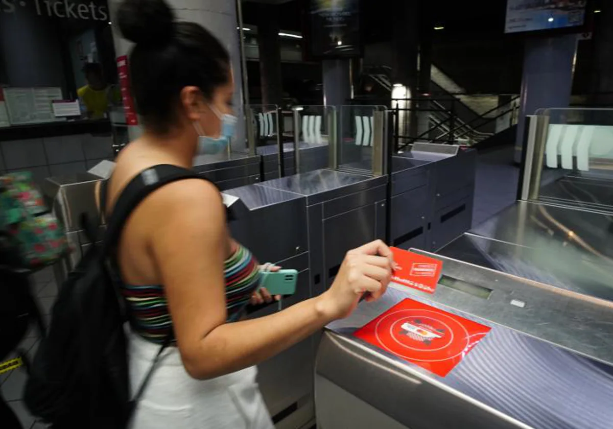 Una usuaria de Metro valida su abono en una estación