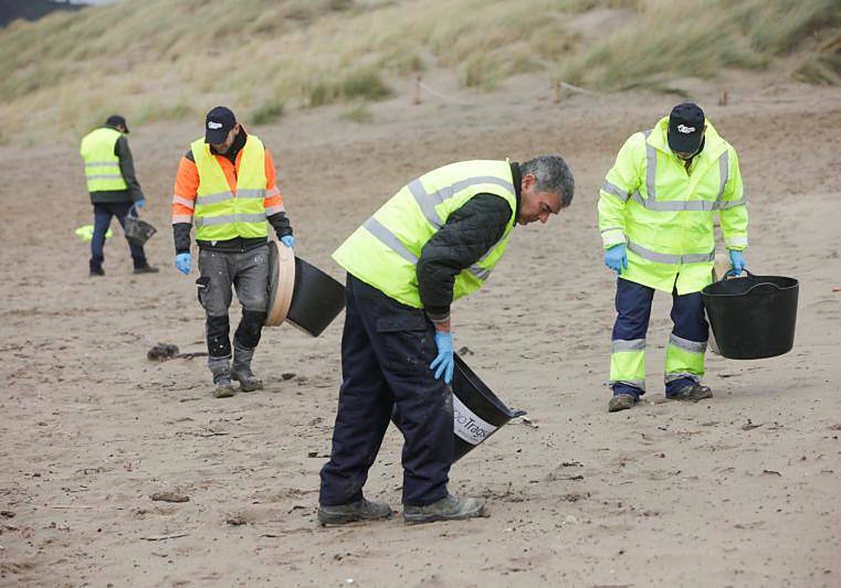 Un equipo de limpieza, este miércoles, en una playa asturiana