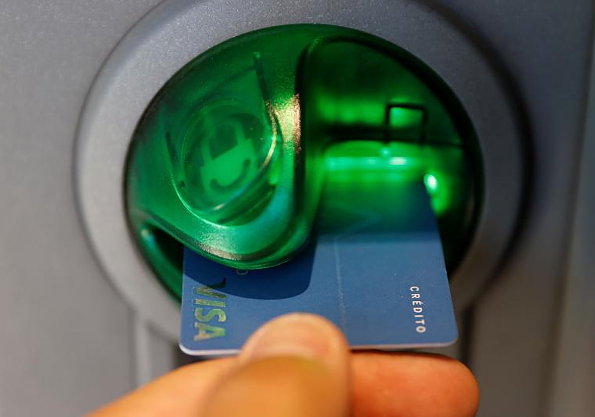 Una persona saca dinero de un cajero de una entidad bancaria