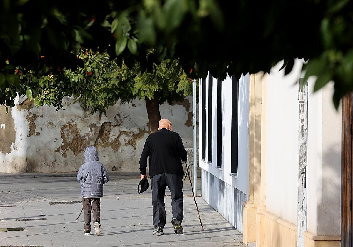 Un niño y una persona mayor, el domingo paseando por la Ribera