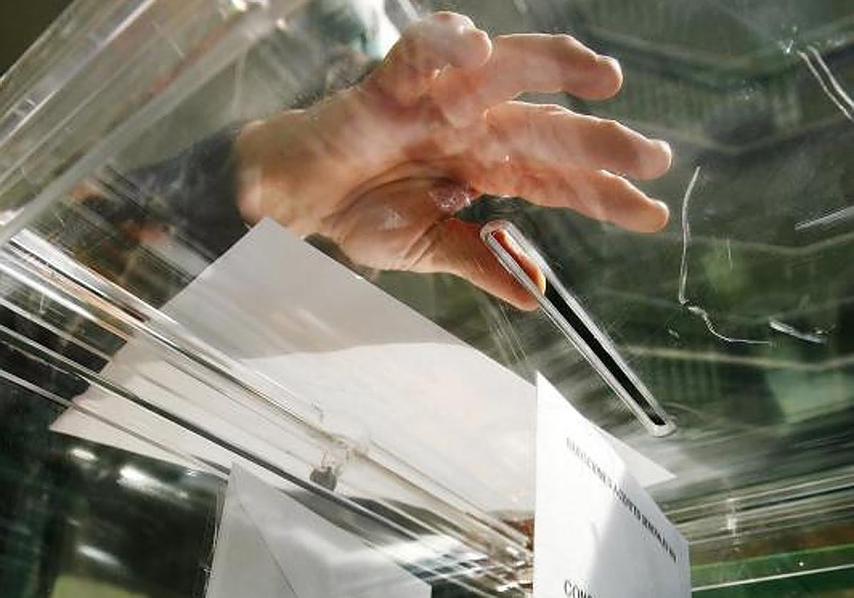 Un votante mete su voto en una urna, foto de archivo