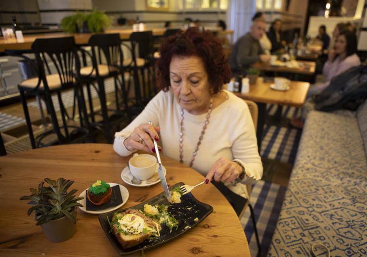 Una mujer desayuna en un local del barrio de Chueca
