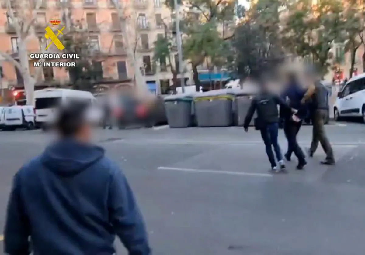 Dos agentes trasladan al presunto yihadista, detenido en Barcelona