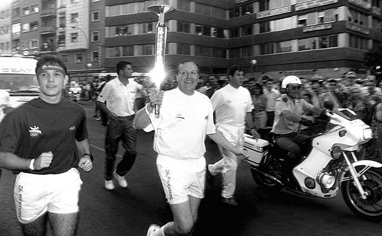 Imagen principal - Arriba, Álvarez del Manzano, corriendo con la antorcha olímpica por Madrid en 1992. Abajo, izq., los entonces príncipes Felipe y Letizia encienden el pebetero en Madrid. Dcha, Ruiz-Gallardón entrando al Metro con el farolillo de la llama olímpica
