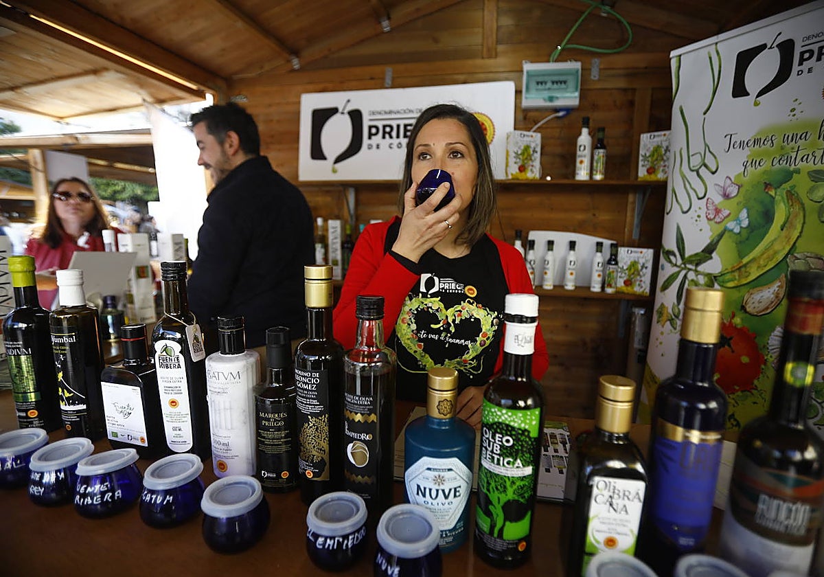 Una mujer cata en el interior de un stand un virgen extra en ei inicio del Festival