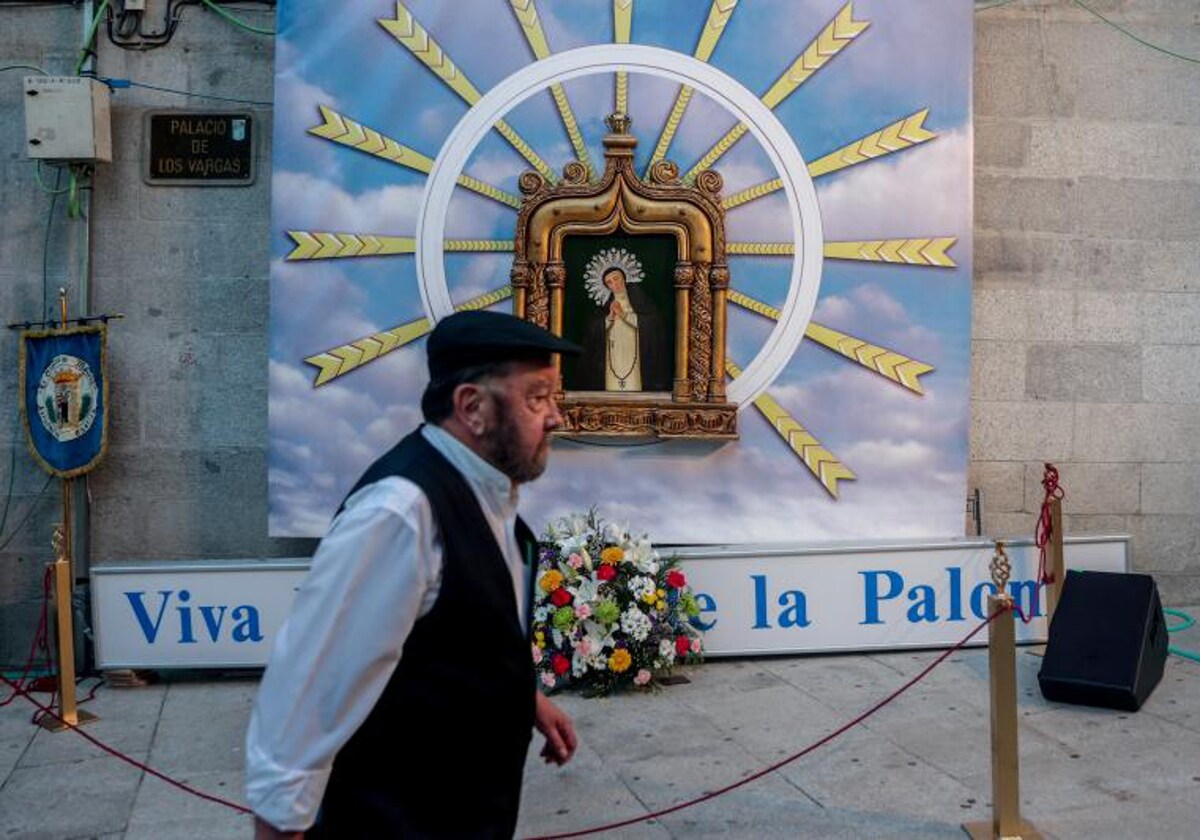 Un castizo pasa frente a un altar dedicado a La Paloma