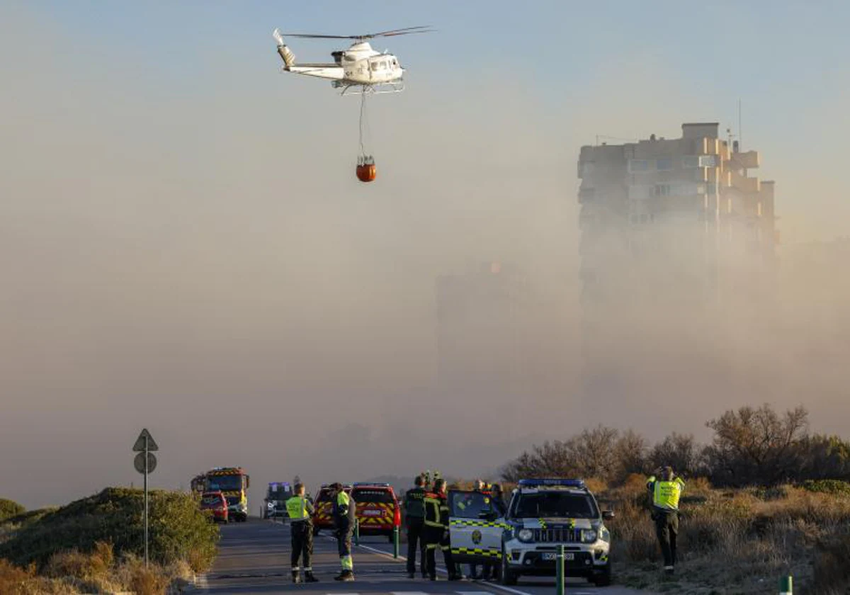 Un helicóptero trabaja en las labores de extinción del incendio forestal de El Saler (Valencia)