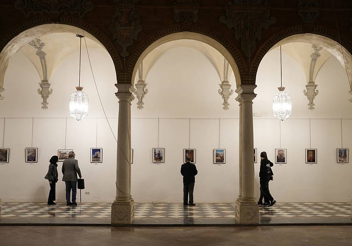 Varios visitantes admiran las fotos de la exposición, este lunes