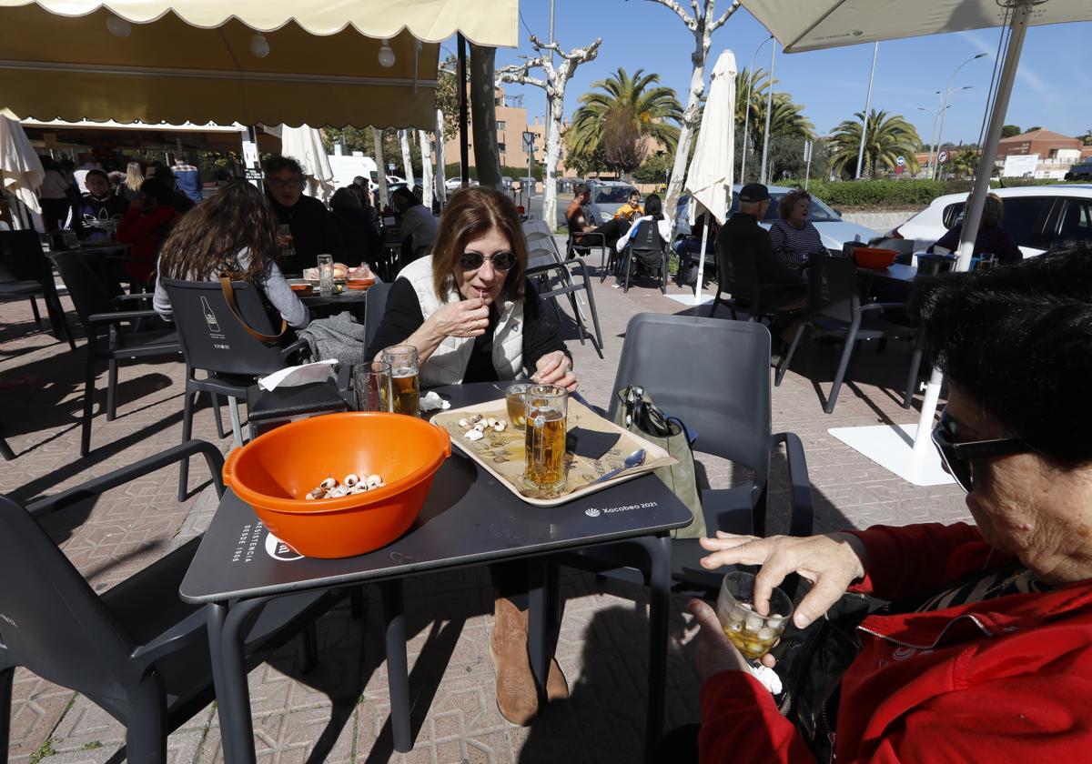 Dos mujeres comiendo caracoles en un puesto de Córdoba