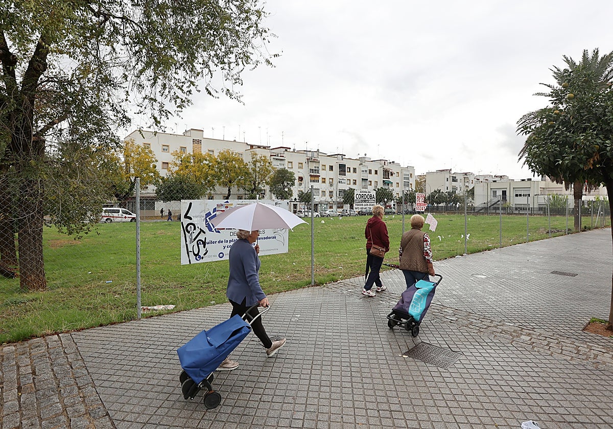 Vecinos pasan delante del solar del Pabellón de la Juventud en el Sector Sur