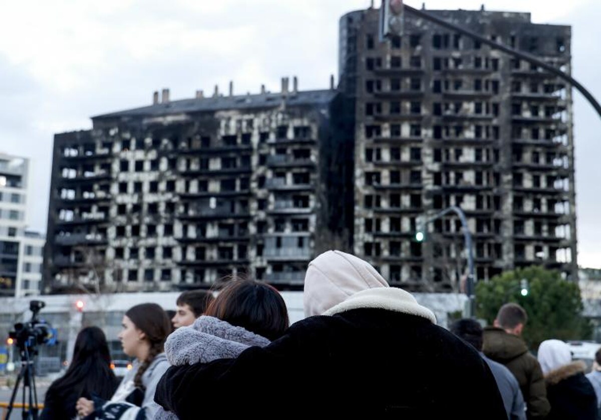 Una pareja contempla el edificio destruido por las llamas