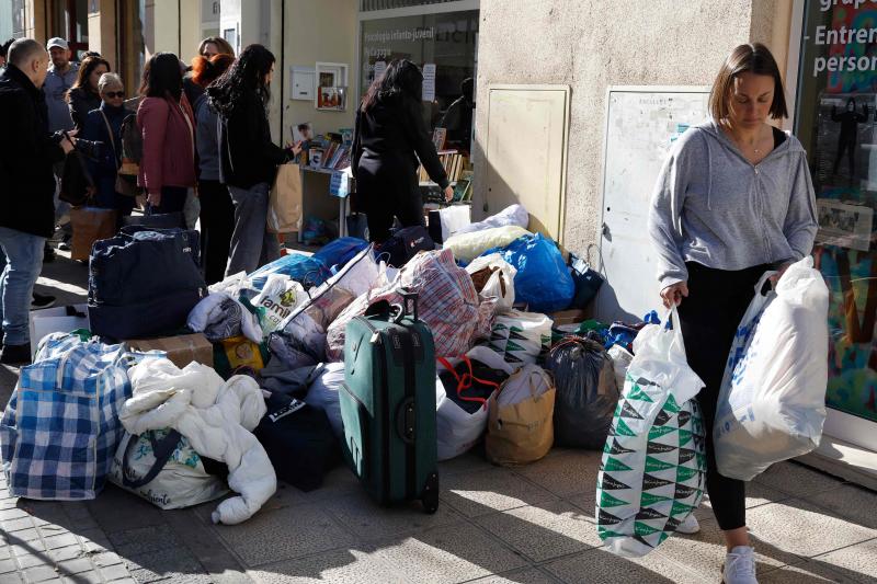 Vecinos llevan ropa a los residentes de las viviendas afectadas por el incendio durante la mañana de este viernes