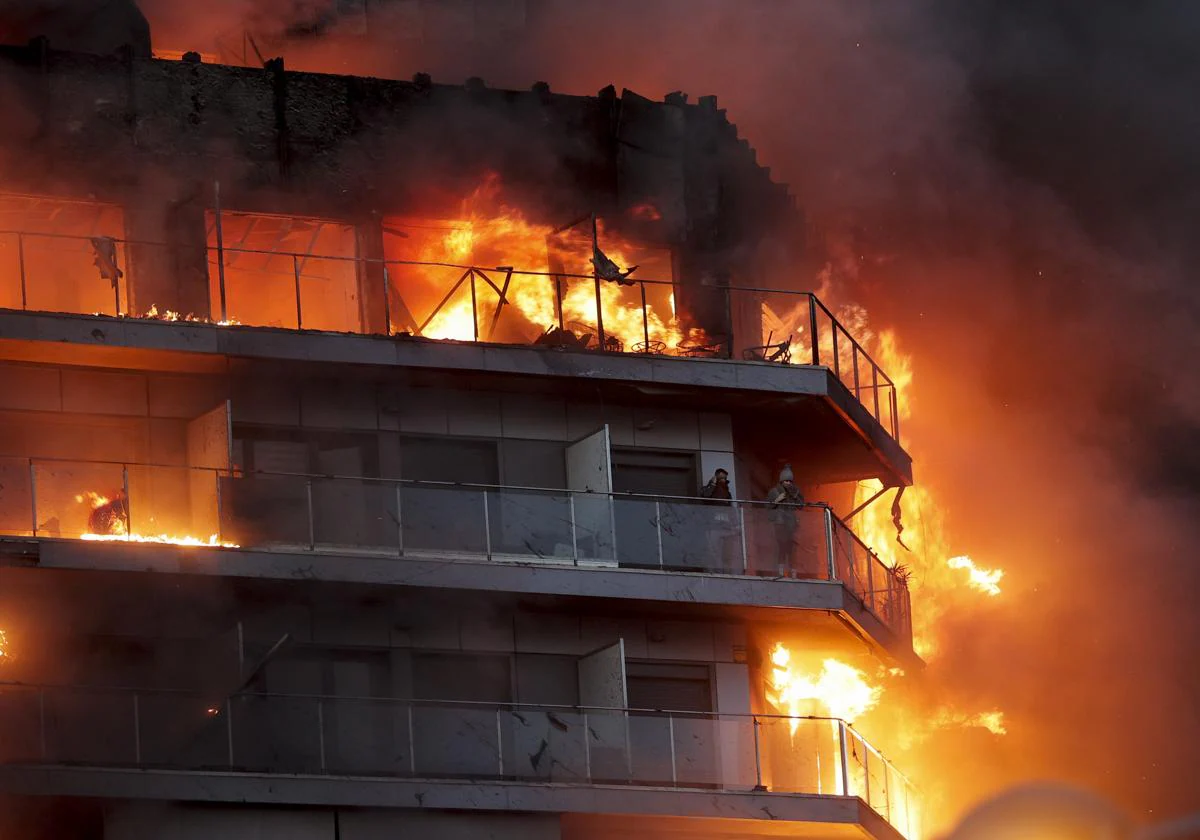 Una imagen del edifcio durante el incendio, con dos personas atraparadas en un balcón