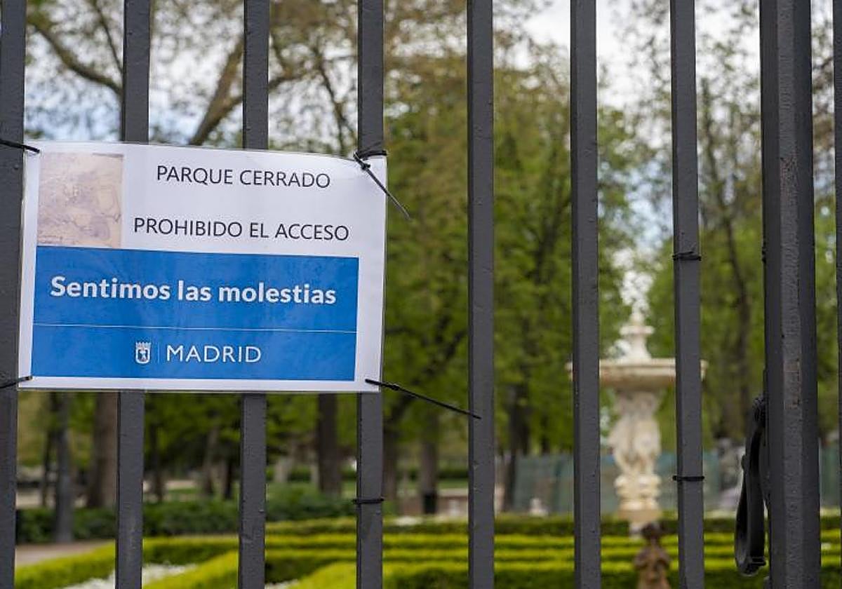 Imagen de archivo de un cartel que anuncia que el Parque del Retiro prohibe el acceso por cierre