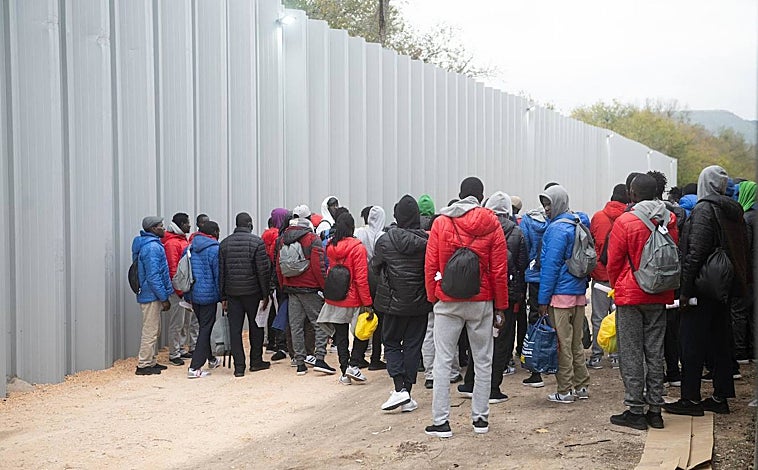 Imagen principal - Decenas de inmigrantes en una de las salas de asilo del aeropuerto de Barajas; en las imágenes de la derecha, un hombre sostiene en un papel la ruta aérea de su grupo hasta alcanzar el campamento de emergencia de Alcalá de Henares.