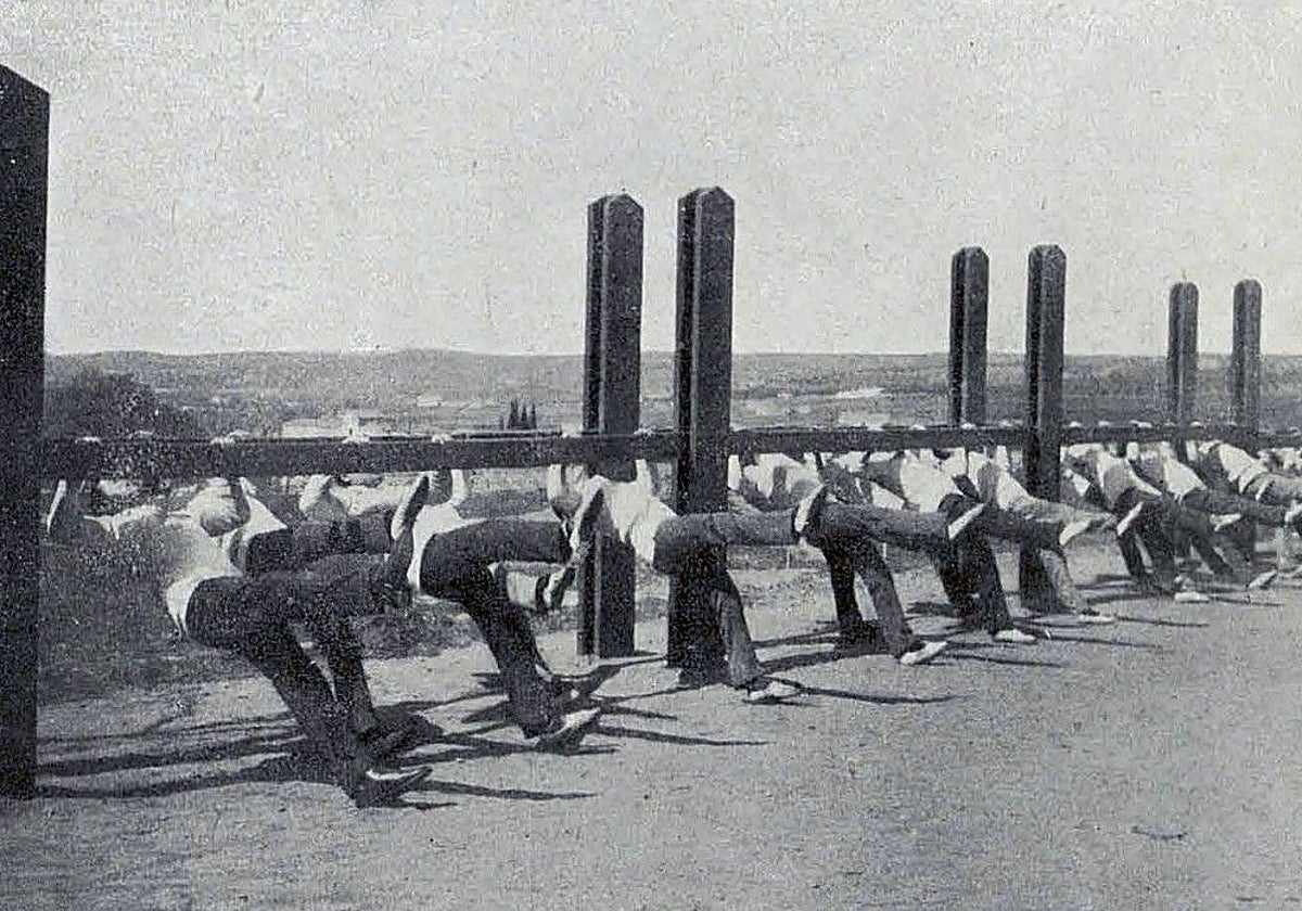 Escuela Central de Gimnasia. Ejercicios de suspensión en una foto recogida en la 'Memoria. Cursos 1920-1921-1923'. Años después, en este lugar se adecuó el gimnasio cubierto que tendría sucesivas reformas. Su estructura exterior permanece aún en la Costanilla de San Lázaro