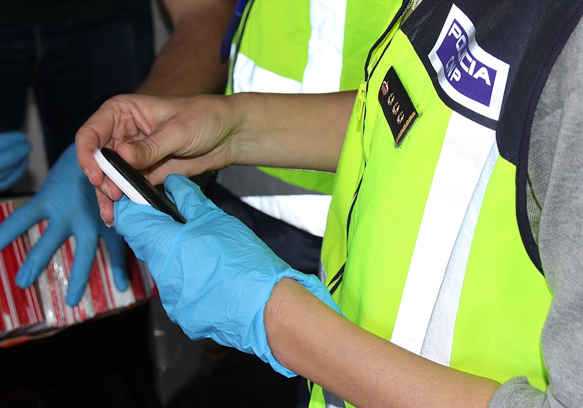 Imagen de un agente de la Policía Nacional con un móvil recuperado