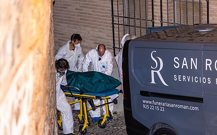 Imagen principal - Miembros de los servicios funerarios trasportan uno de los cuatro cadáveres encontrados este martes en la calle Santa Leocadia de Toledo