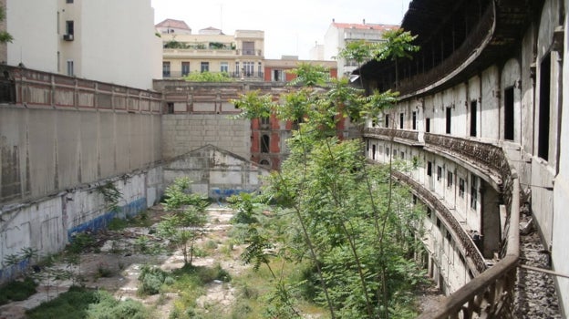 Imagen después - El estado de deterioro del frontón Beti Jai, en 1977, con la estructura del taller en el patio; y su posterior aspecto, en 2007, completamente abandonado