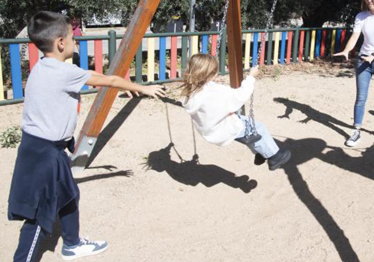 Imagen de archivo de dos niños jugando en un columpio