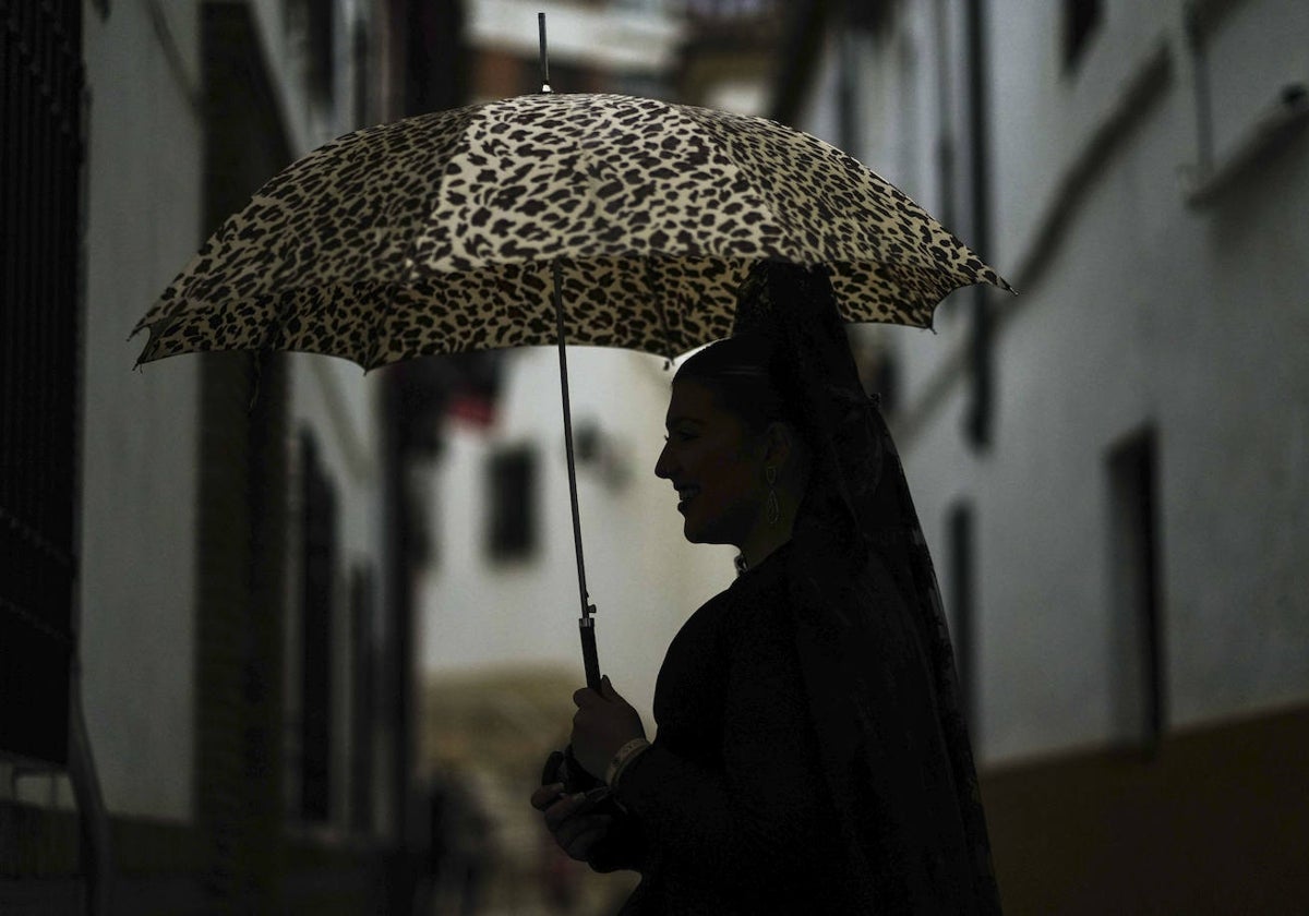 Una mujer vestida de mantilla con un paraguas