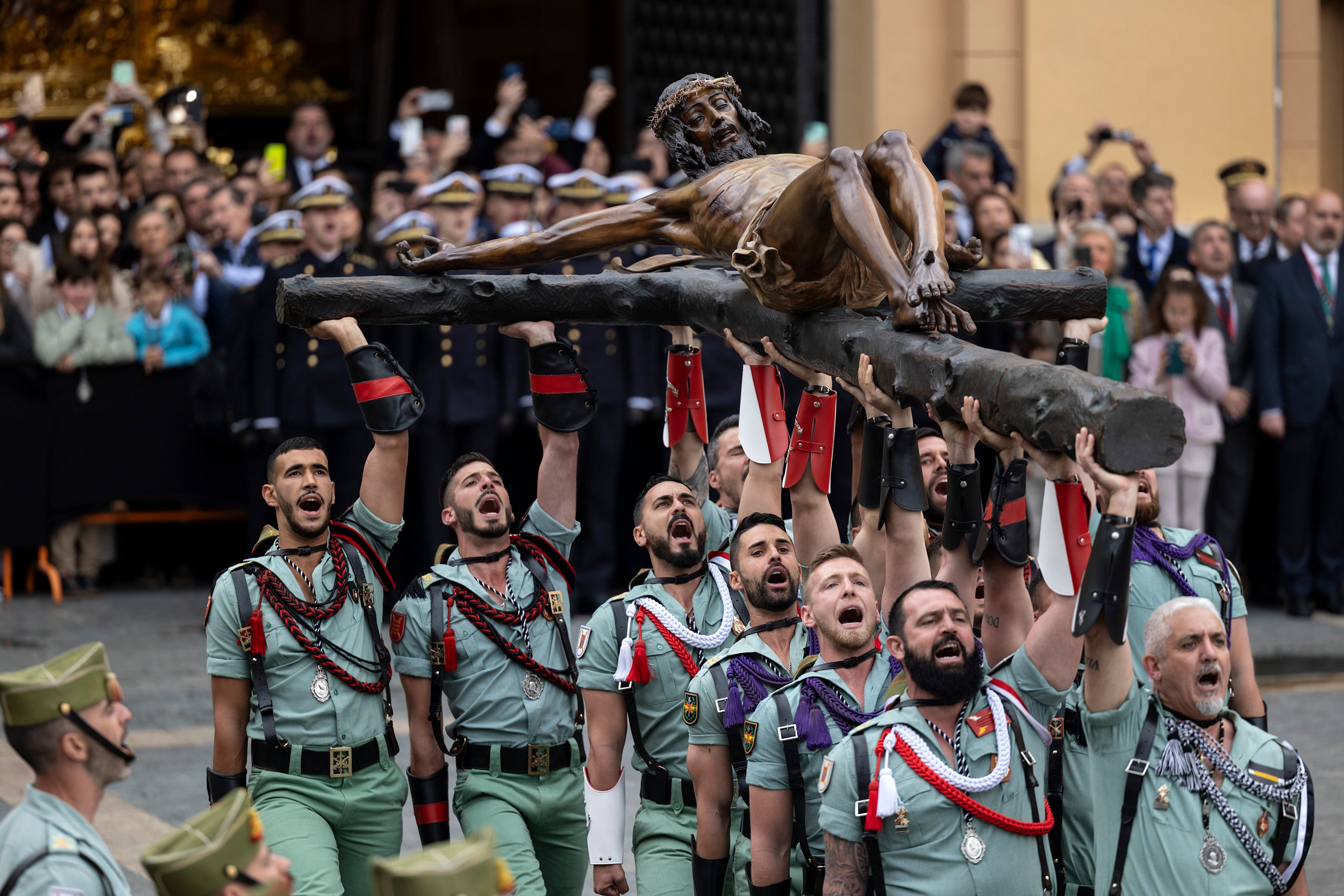 Varios legionarios levantan al Cristo de la Buena Muerte