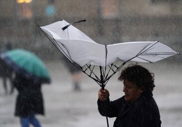 Una mujer sujeta un paraguas durante el paso de una borrasca en Santiago