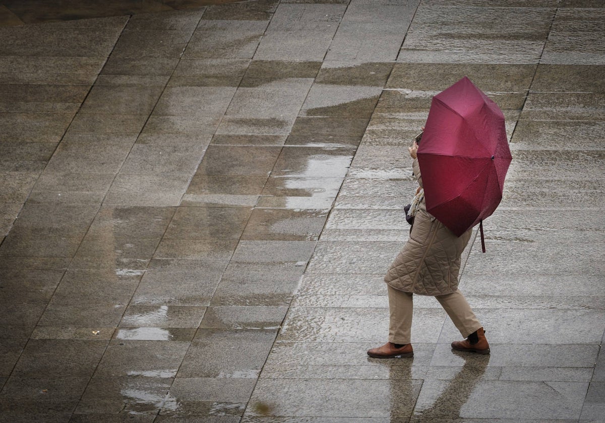 Una persona camina bajo la lluvia