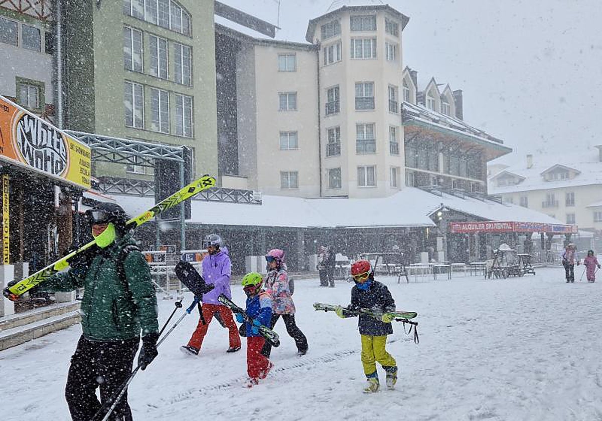 Esquiadores cruzan la plaza principal de Pradollano, en Sierra Nevada