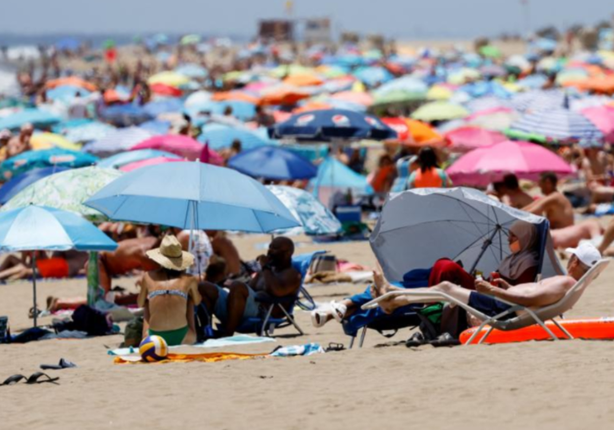 Turistas en Playa del Inglés (Gran Canaria) en verano en foto  de archivo