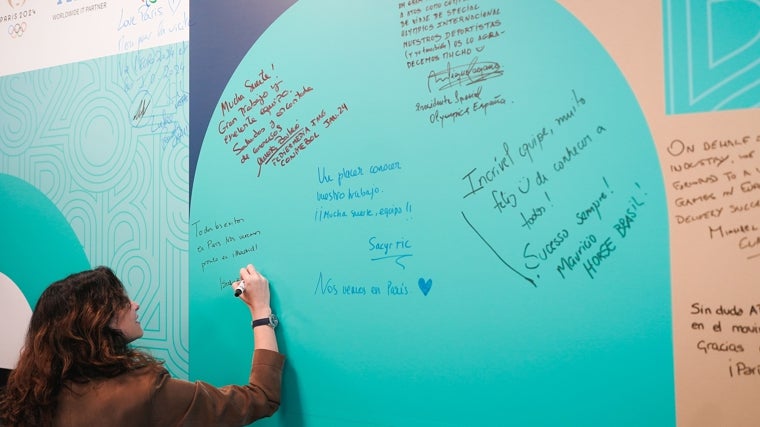 Díaz Ayuso firma en una gran pizarra en la sede de Atos