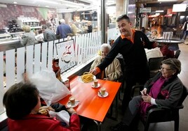 Un grupo de clientas en  una mesa exterior de Cafetería Milán para comer churros