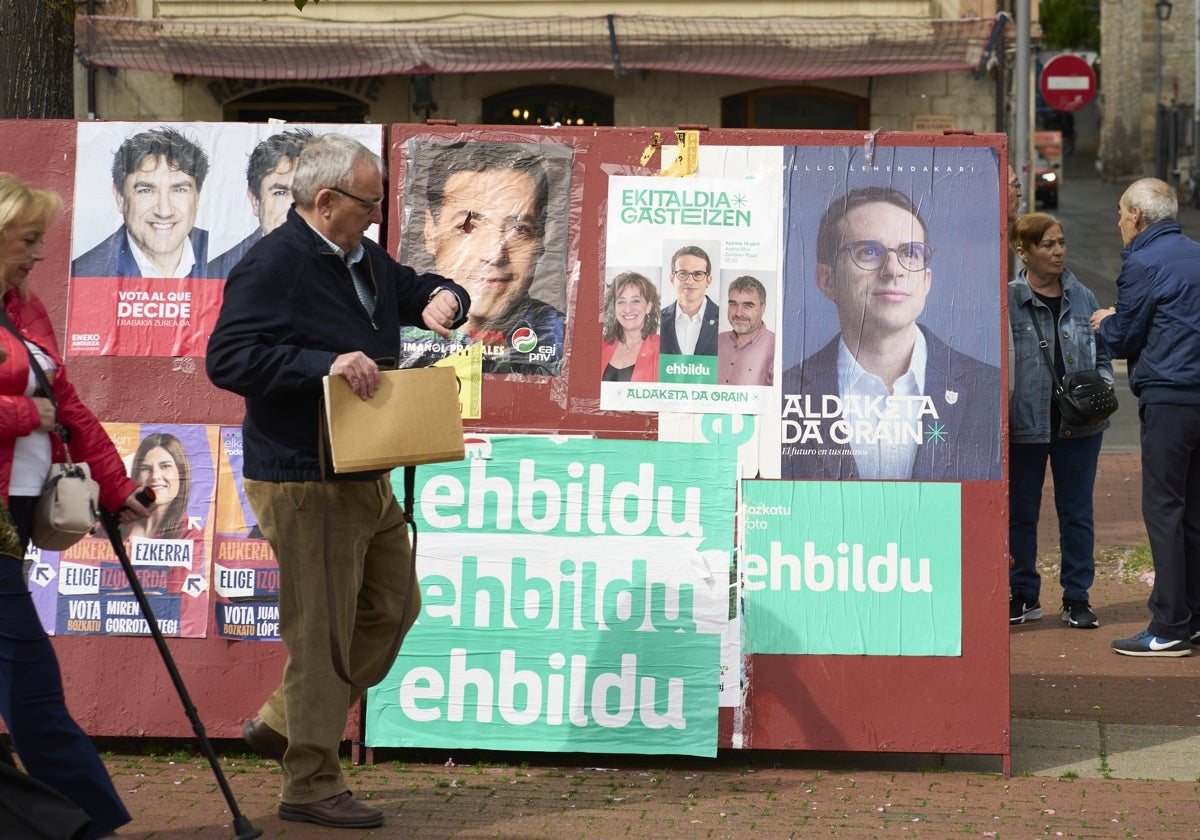 Un hombre pasa por delante de un panel electoral en Vitoria