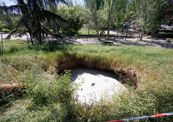 Imagen secundaria 1 - Sobre estas líneas y a la izquierda, los obreros trabajando esta semana para tapar el socavón, que alcanza los 4 metros de diámetro. Abajo, una bomba que extrae el agua para vertirla en la alcantarilla