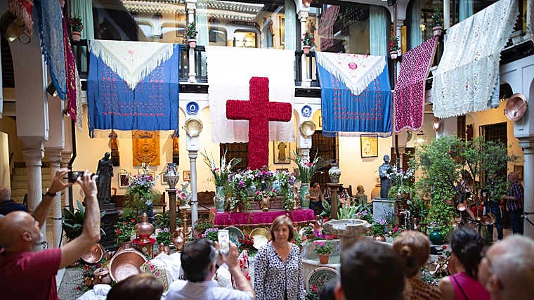La cruz, acompañada de mantones, cerámica y otros elementos típicos de Granada