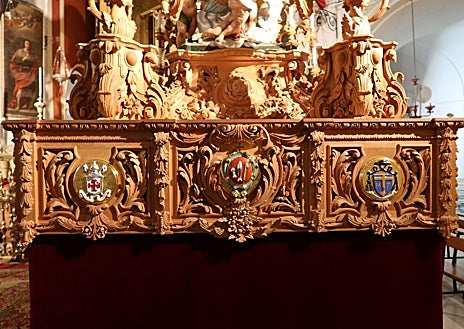 Imagen secundaria 1 - En la fotografía superior, respiradero lateral del paso de San Rafael, que estrena talla y escudos nobiliarios. A la izquierda, el frontal, con los escudos de las hermandades del Santo Sepulcro y San Rafael, y el del canónigo arcediano, Fernando Cruz Conde. A la derecha, en la trasera del paso el escudo del Real Círculo de la Amistad 