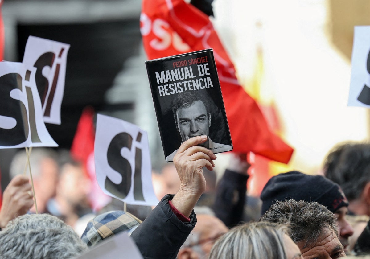 Un ciudadano alza un 'Manual de Resistencia' en la movilización socialista del pasado sábado en Ferraz