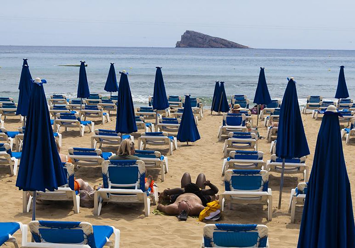 Turistas en las tumbonas en la playa de Levante de Benidorm.