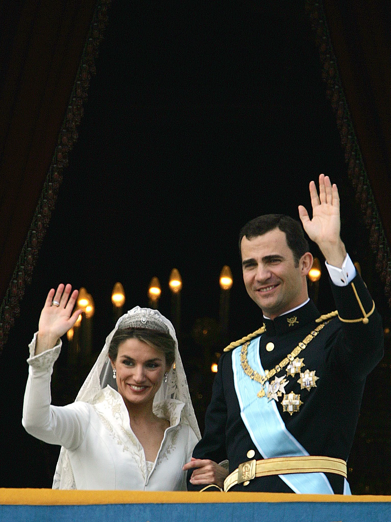 A gritos de «¡que vivan los novios!», los Reyes saludaron desde el balcón situado sobre la Puerta del Príncipe del Palacio Real a los cientos de madrileños que aguardaban impacientes por los alrededores para felicitar a los recién casados. A pesar de la insistencia de los allí presentes para que los esposados se besaran, tampoco se produjo en el balcón aquella anhelada imagen. La terraza se encontraba engalanada con el escudo de armas del Príncipe de Asturias. Al saludo se unió Don Juan Carlos y Doña Sofía y, posteriormente, demás miembros de la Familia Real, junto a los padres de Doña Letizia. 
